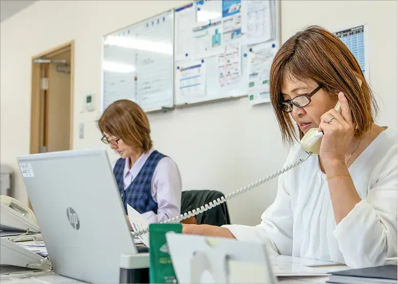 事務所で電話対応をするスタッフ