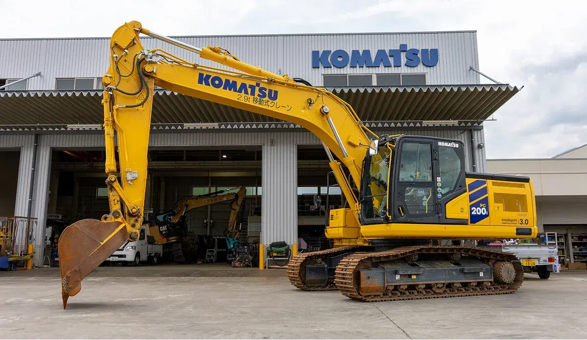 コマツの看板を掲げた工場と油圧ショベル